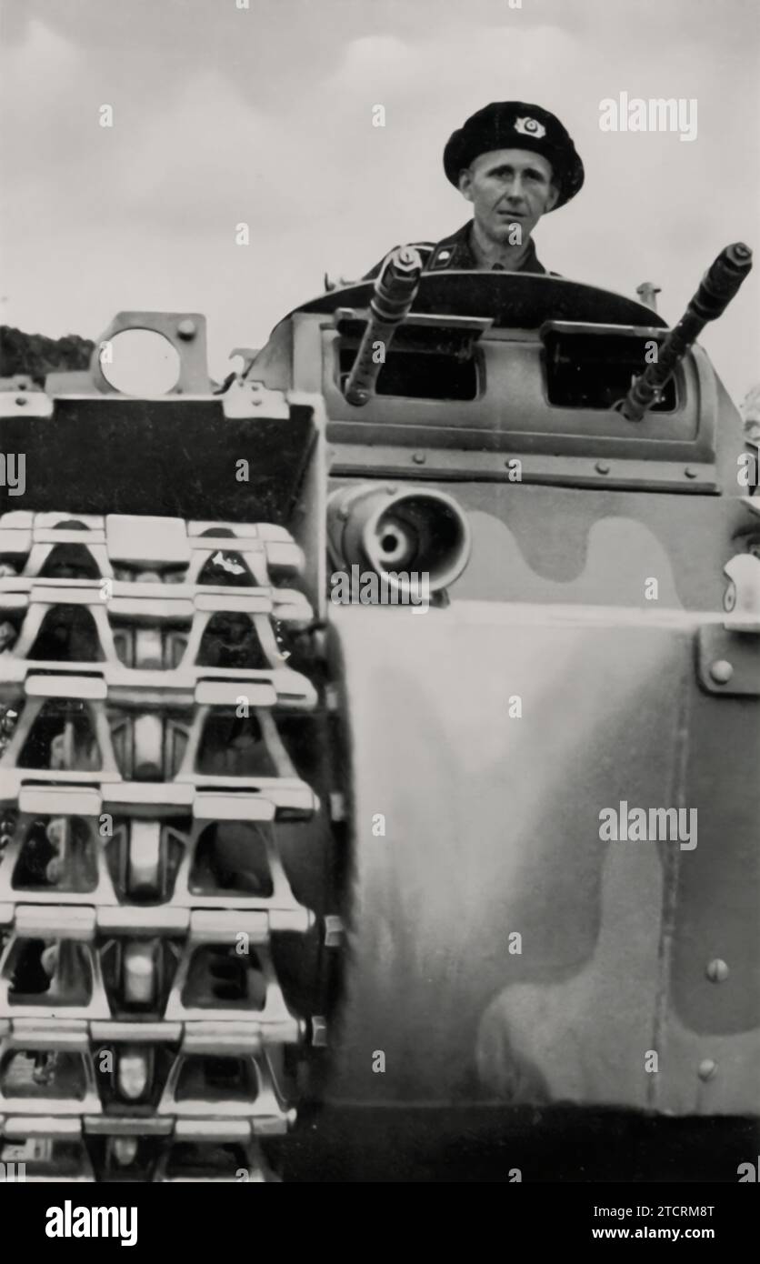 Dans 'Die Neue Tankwaffe' (la nouvelle arme de char), un soldat allemand est visible dans la trappe supérieure d'un char, symbolisant la modernisation de la Wehrmacht et l'introduction de techniques de guerre blindées avancées. Cette image reflète le changement significatif de la stratégie militaire au cours de cette période, soulignant le rôle des chars en tant que composante clé de l'arsenal militaire en expansion et en évolution de l'Allemagne. Banque D'Images