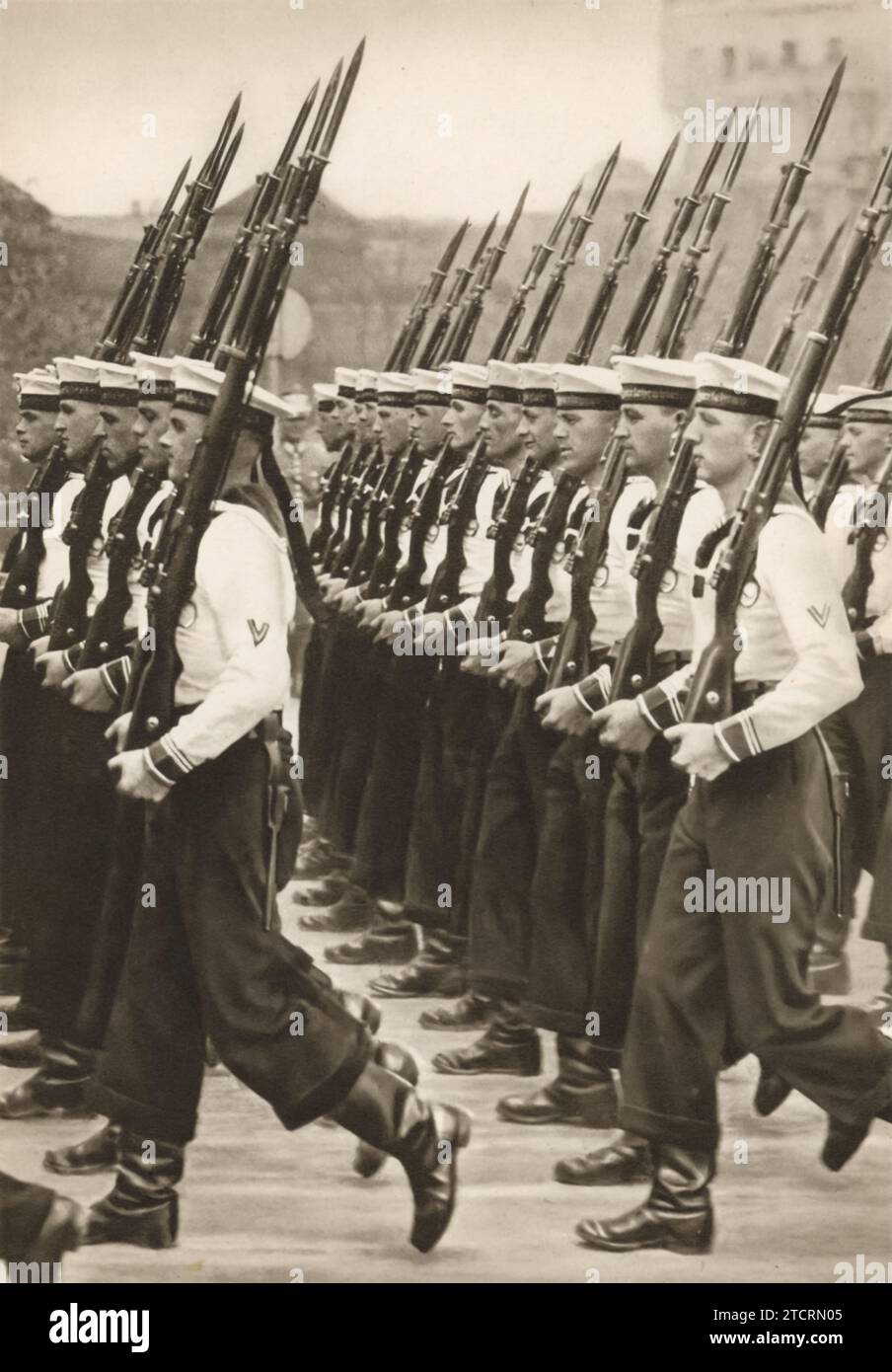 Dans l'image intitulée « nos garçons bleus », des soldats allemands et des membres de la Kriegsmarine sont capturés lors d'une marche de formation. Le terme « garçons bleus » est un clin d'œil à leurs uniformes navals distinctifs, les distinguant de la tenue vestimentaire de l'armée. Cette marche illustre la discipline et l'unité emblématiques de la Kriegsmarine, la force navale allemande pendant la Seconde Guerre mondiale De tels affichages sont essentiels pour maintenir un moral élevé et favoriser un sentiment de camaraderie parmi les marines. Banque D'Images
