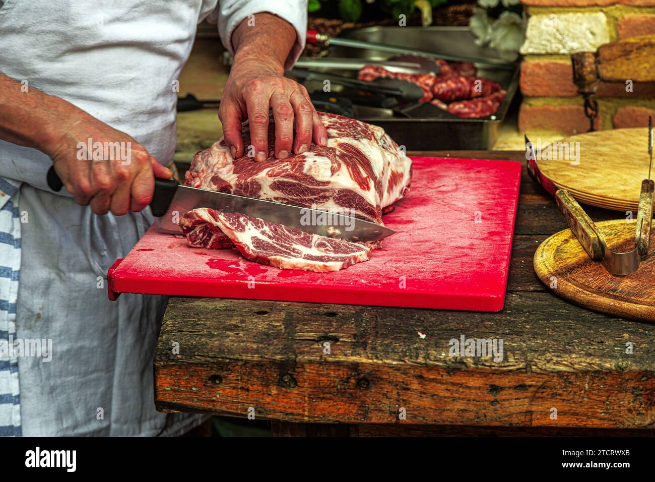 Dans une cuisine extérieure, un chef prépare de la viande pour faire des rôtis grillés au barbecue. Abruzzes, Italie. Europe Banque D'Images