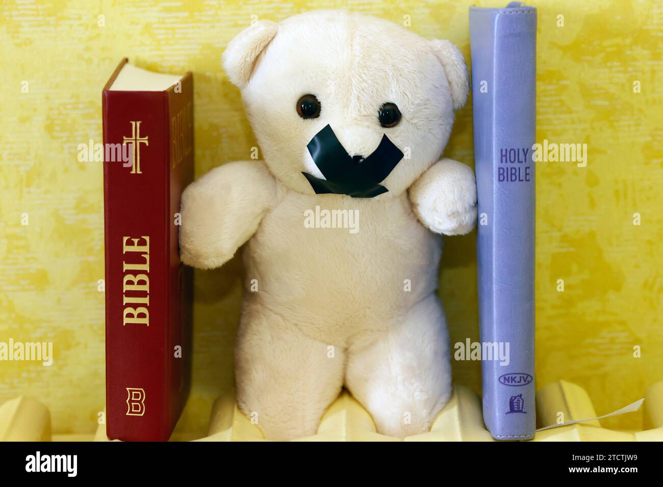 Bibles et ours en peluche avec du ruban adhésif sur la bouche. Symbole du silence sur les abus d'enfants et les victimes dans l'église chrétienne. Banque D'Images