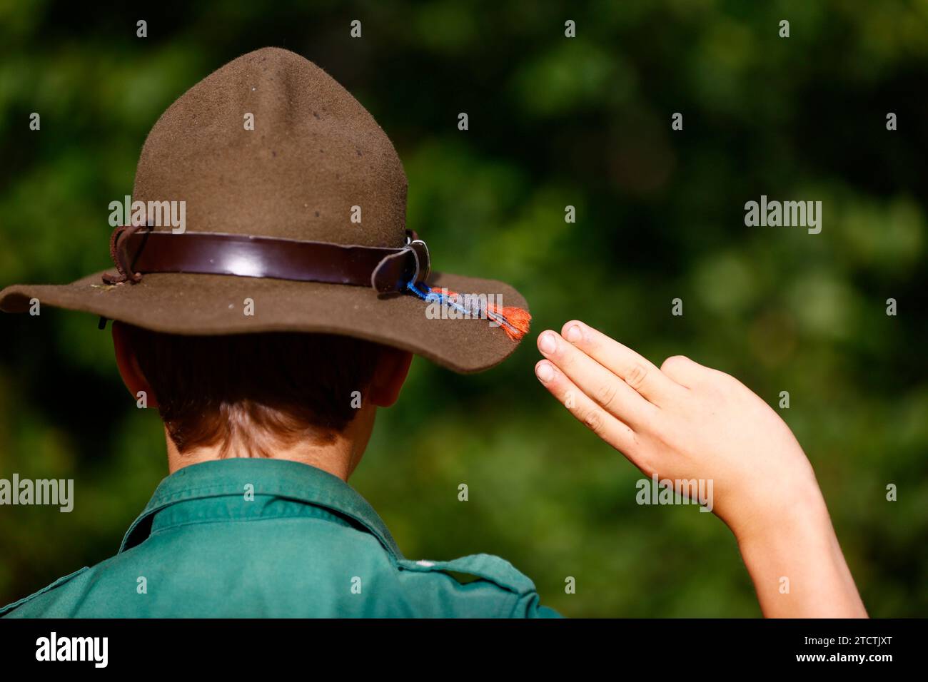 Boy scout en uniforme effectue un salut à trois doigts. Geste de la main symbole Scout. France. Banque D'Images