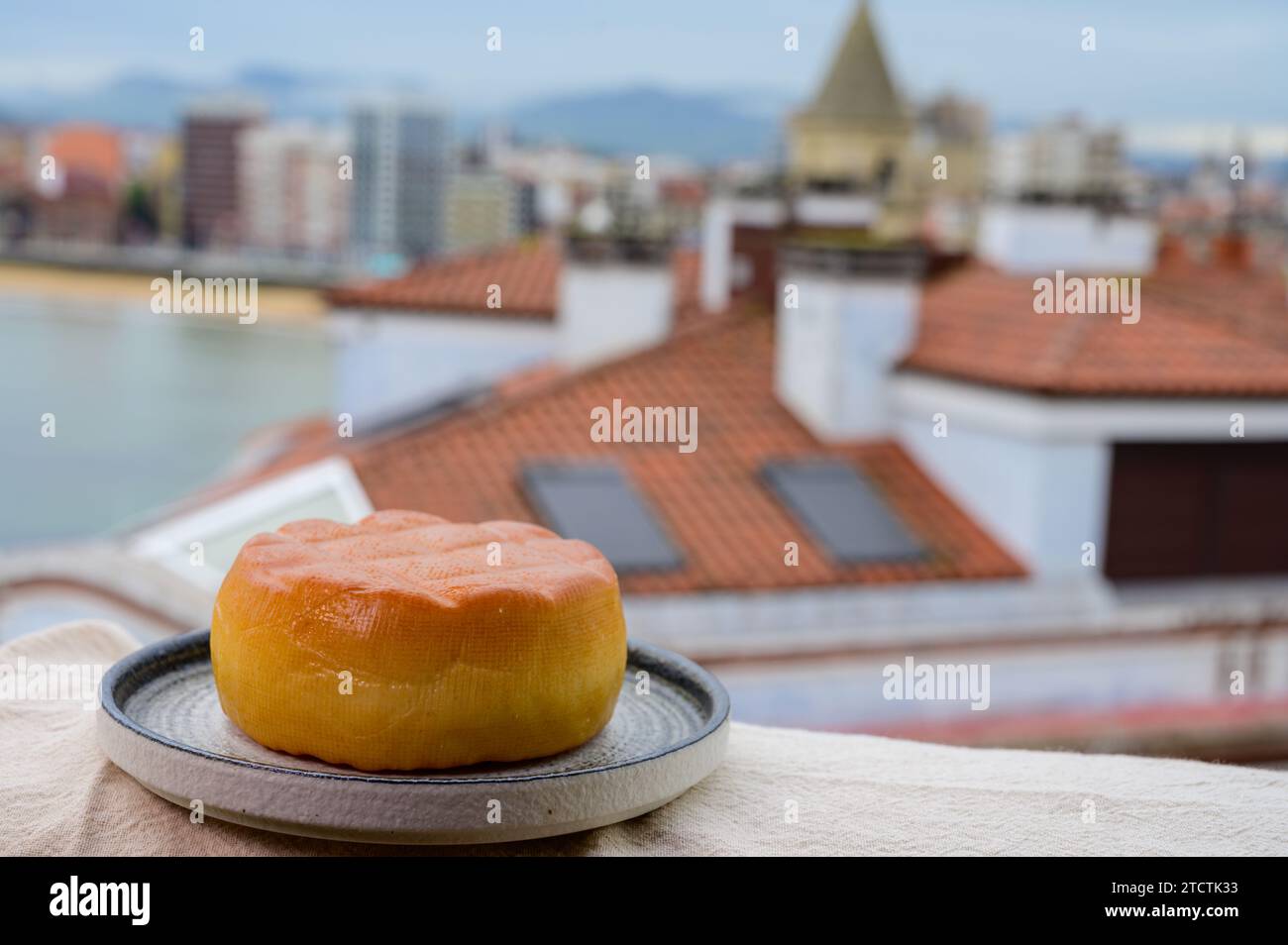 Fromage de vache fumé espagnol de Pria, Asturies, servi en plein air avec vue sur la plage de San Lorenzo et la promenade de Gijon Banque D'Images