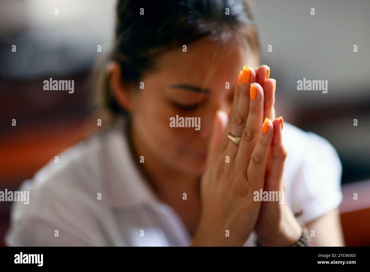 Femme catholique priant seule dans une église. CAN Tho. Vietnam. Banque D'Images
