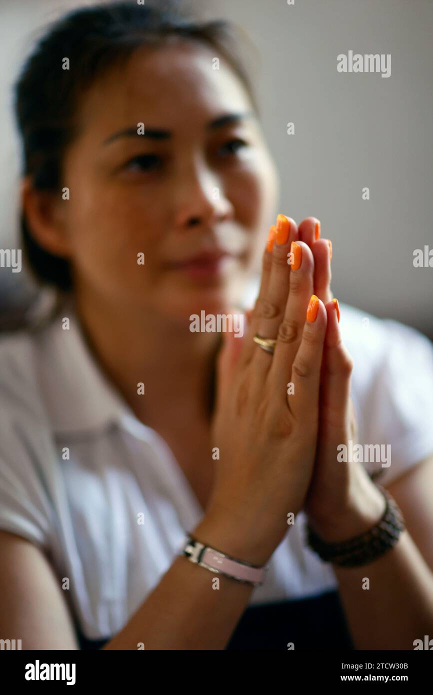 Femme catholique priant seule dans une église. CAN Tho. Vietnam. Banque D'Images