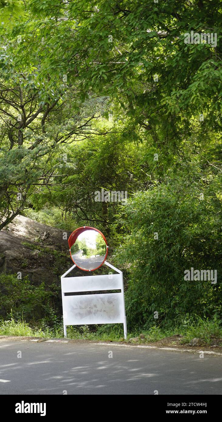 Miroir convexe du trafic extérieur dans les virages en épingle à cheveux et la route ascendante en route vers le sommet de la colline kodaikanal. Installé pour améliorer la sécurité. Banque D'Images