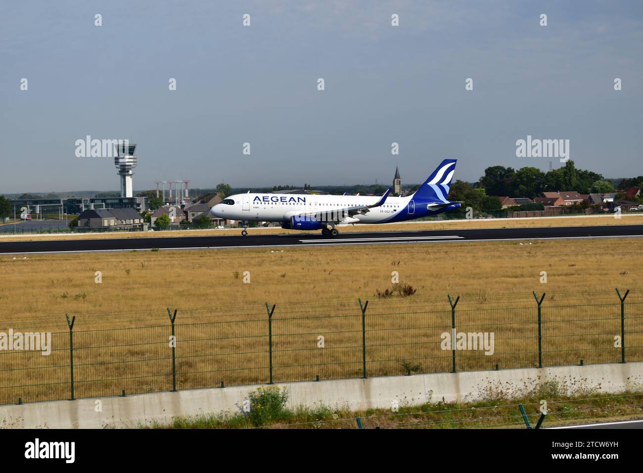 Aegean Airlines A320 atterrit sur la piste 25L avec de la fumée blanche provenant des pneus des trains d'atterrissage à l'aéroport international de Bruxelles Banque D'Images