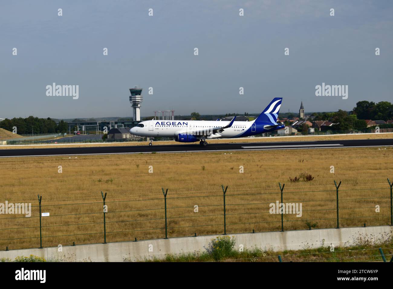 Aegean Airlines A320 atterrit sur la piste 25L avec de la fumée blanche provenant des pneus des trains d'atterrissage à l'aéroport international de Bruxelles Banque D'Images