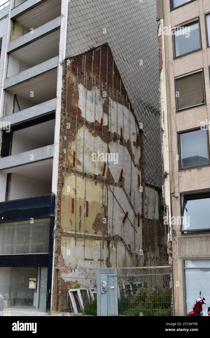 Vieux restes de briques d'une maison détruite intégrée dans le côté d'un immeuble d'habitation plus récent dans le centre-ville d'Anvers Banque D'Images