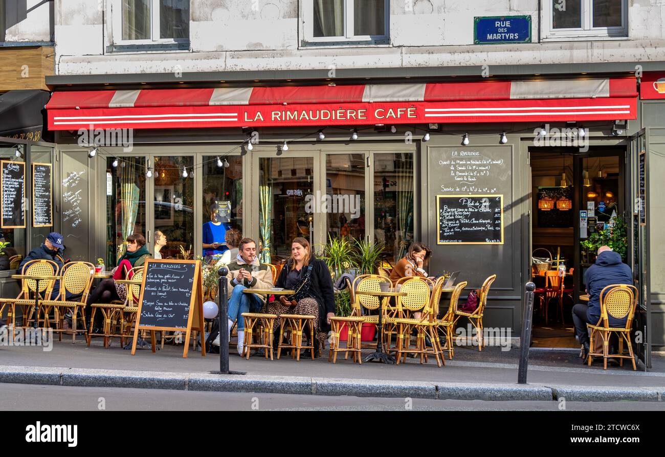 Les gens assis dehors sirotant un verre au café la Rimaudière sur la rue des Martyrs, Paris, France Banque D'Images