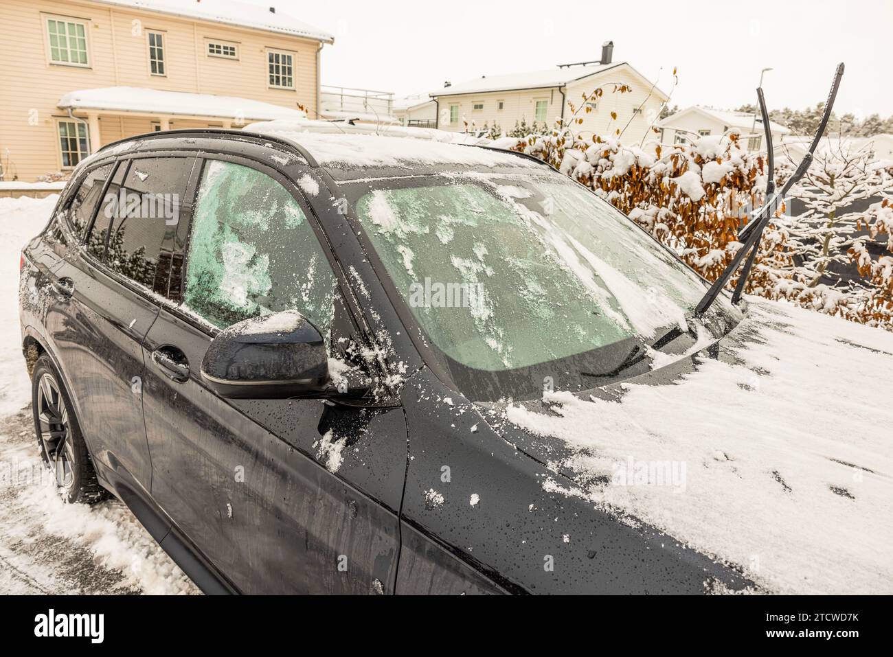 Vue d'une voiture dans la glace et la neige, avec des essuie-glaces surélevés par une froide journée d'hiver. Suède. Banque D'Images