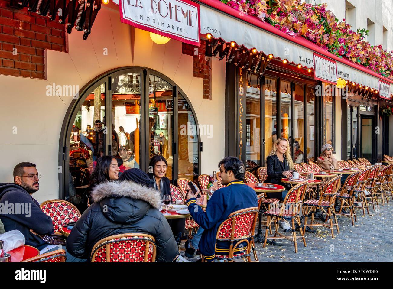Les gens assis dehors sirotant un verre à la Bohème Montmartre, un restaurant français à Montmartre dans le 18e arrondissement de Paris, France Banque D'Images