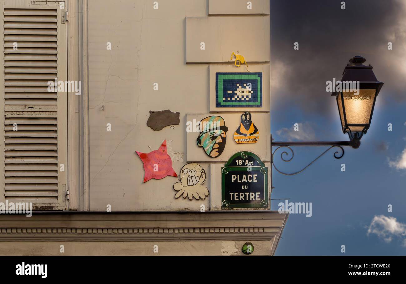 Panneau de rue avec art de rue et un lampadaire fixé au mur, Montmartre Paris, France Banque D'Images