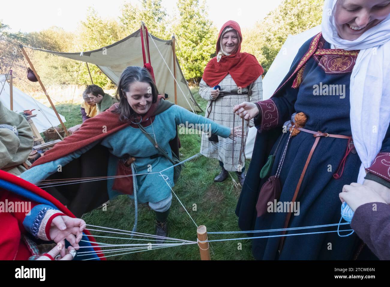 Angleterre, East Sussex, bataille, le festival annuel de reconstitution de la bataille de Hastings d'octobre, groupe de femmes habillées en costume médiéval Spinning main WO Banque D'Images