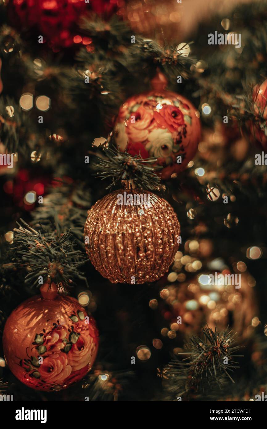 Boule de Noël dorée accrochée sur un arbre de Noël avec guirlande 