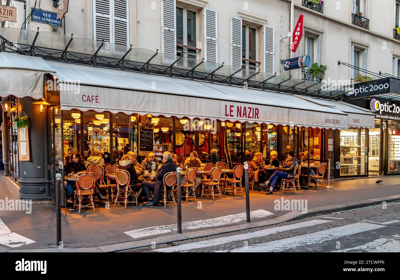 Les gens assis dehors sur la terrrace au café le Nazir , un restaurant / café de la rue des Abbesses à Montmartre dans le 18ème arrondissement de Paris Banque D'Images