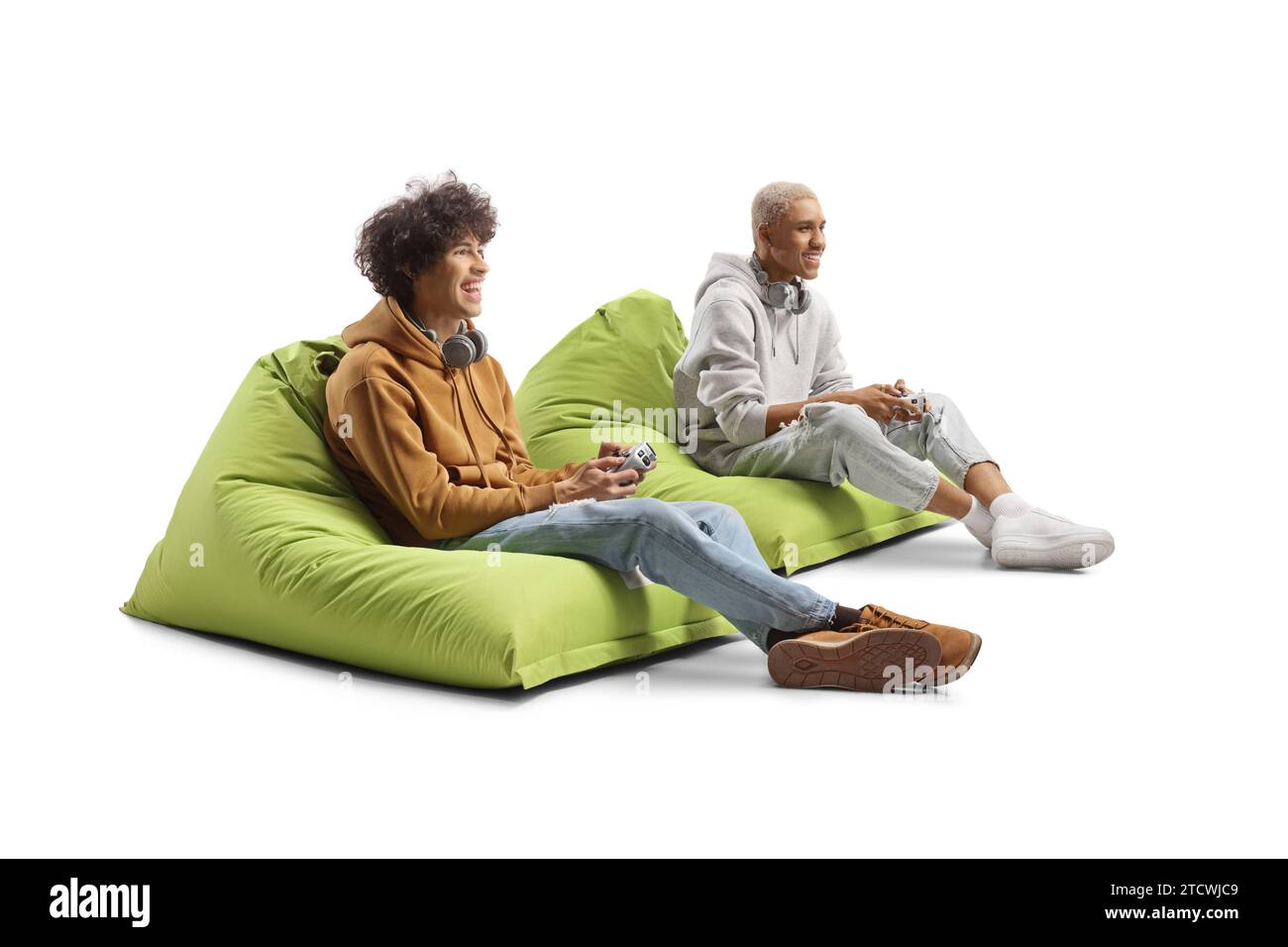 Afro-américain et caucasien gars assis sur des sacs de haricots et jouant à un jeu vidéo avec des joysticks isolés sur fond blanc Banque D'Images