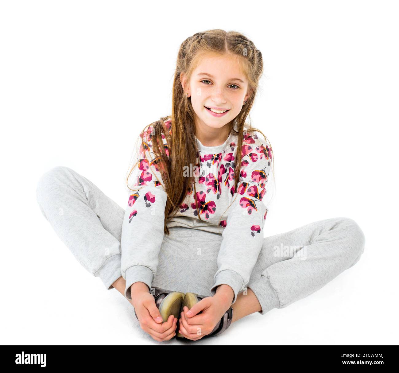 Belle adolescente font l'étirement de papillon assis et sourires isolés sur fond blanc Banque D'Images