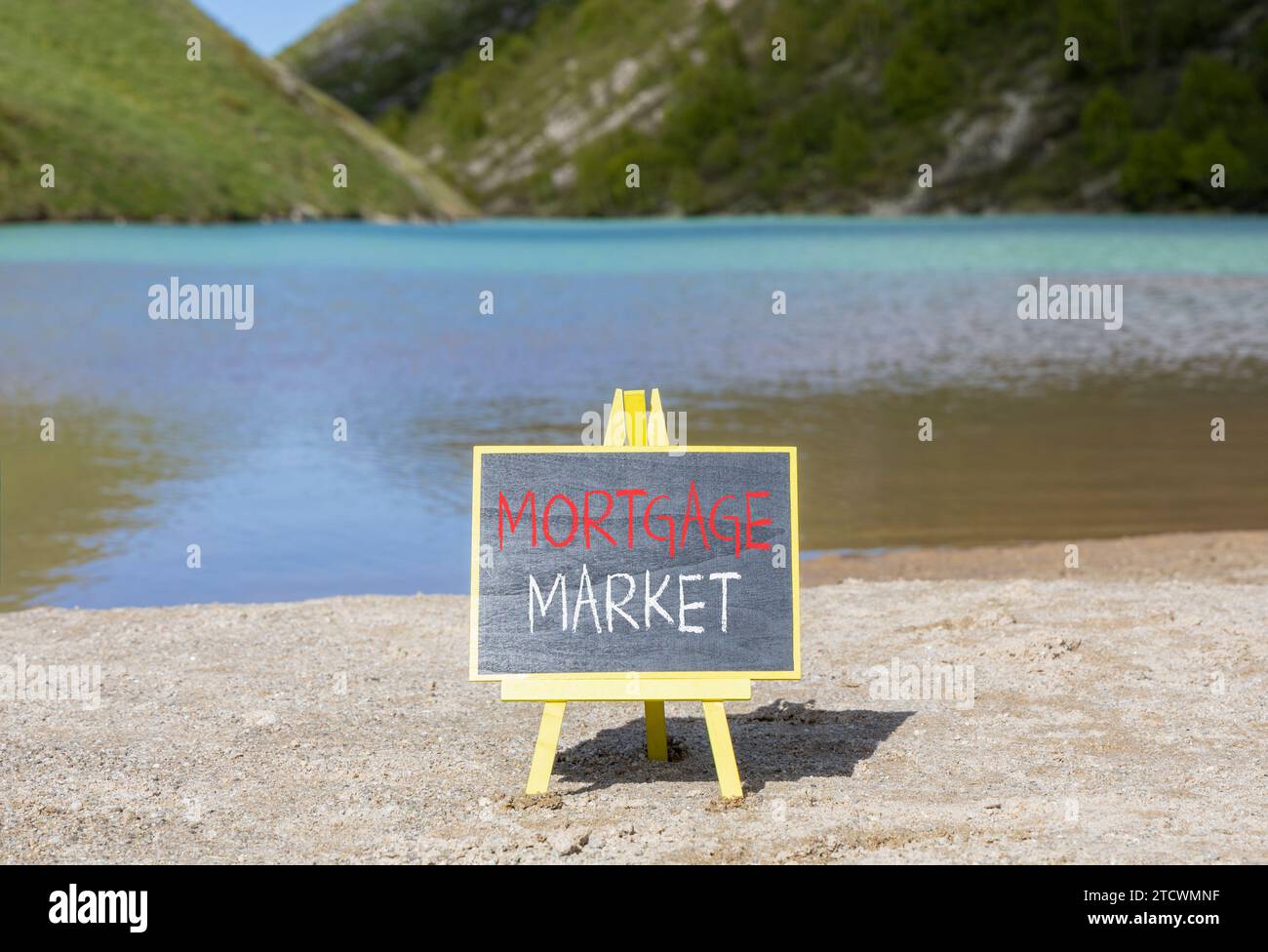 Symbole du marché hypothécaire. Mots concept marché hypothécaire sur beau tableau noir de craie. Beau fond de lac de montagne de plage de sable. Or Banque D'Images