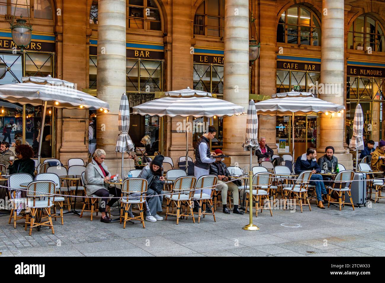 Les gens assis sur la terrasse à le Nemours, une brasserie à la mode avec une terrasse près du Palais Royal, Paris, France Banque D'Images