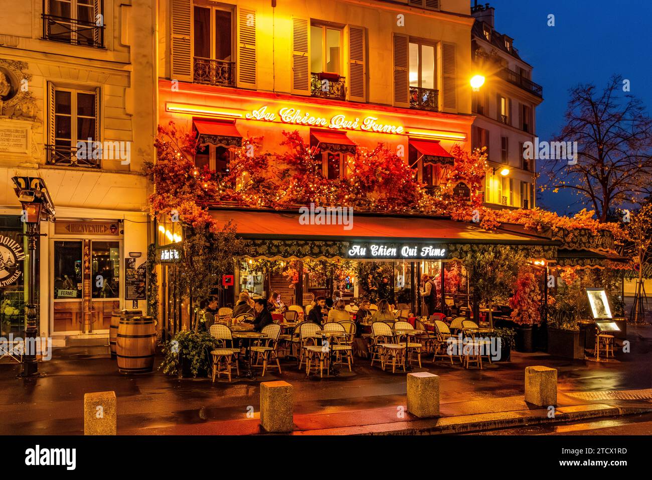 Personnes assises sur la terrasse en plein air profitant d'une soirée au chien qui fume, rue du Pont neuf , dans le quartier des Halles de Paris France Banque D'Images