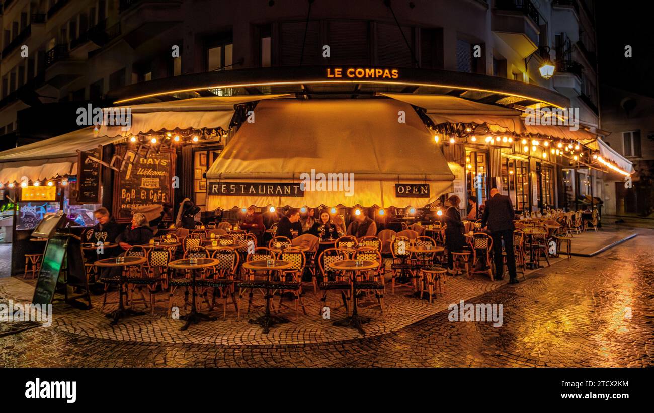 Les gens dehors sur la terrasse profitent d'une soirée au Compas, un restaurant, brasserie sur la rue Montorgueil dans le 2e arrondissement de Paris, France Banque D'Images