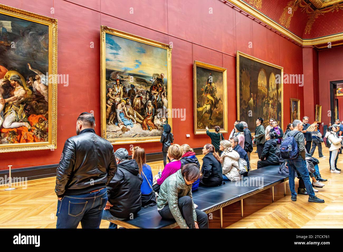 Les gens regardant les grandes peintures Frech hun dans les chambres rouges dans l'aile Denon du Louvre, Paris France Banque D'Images