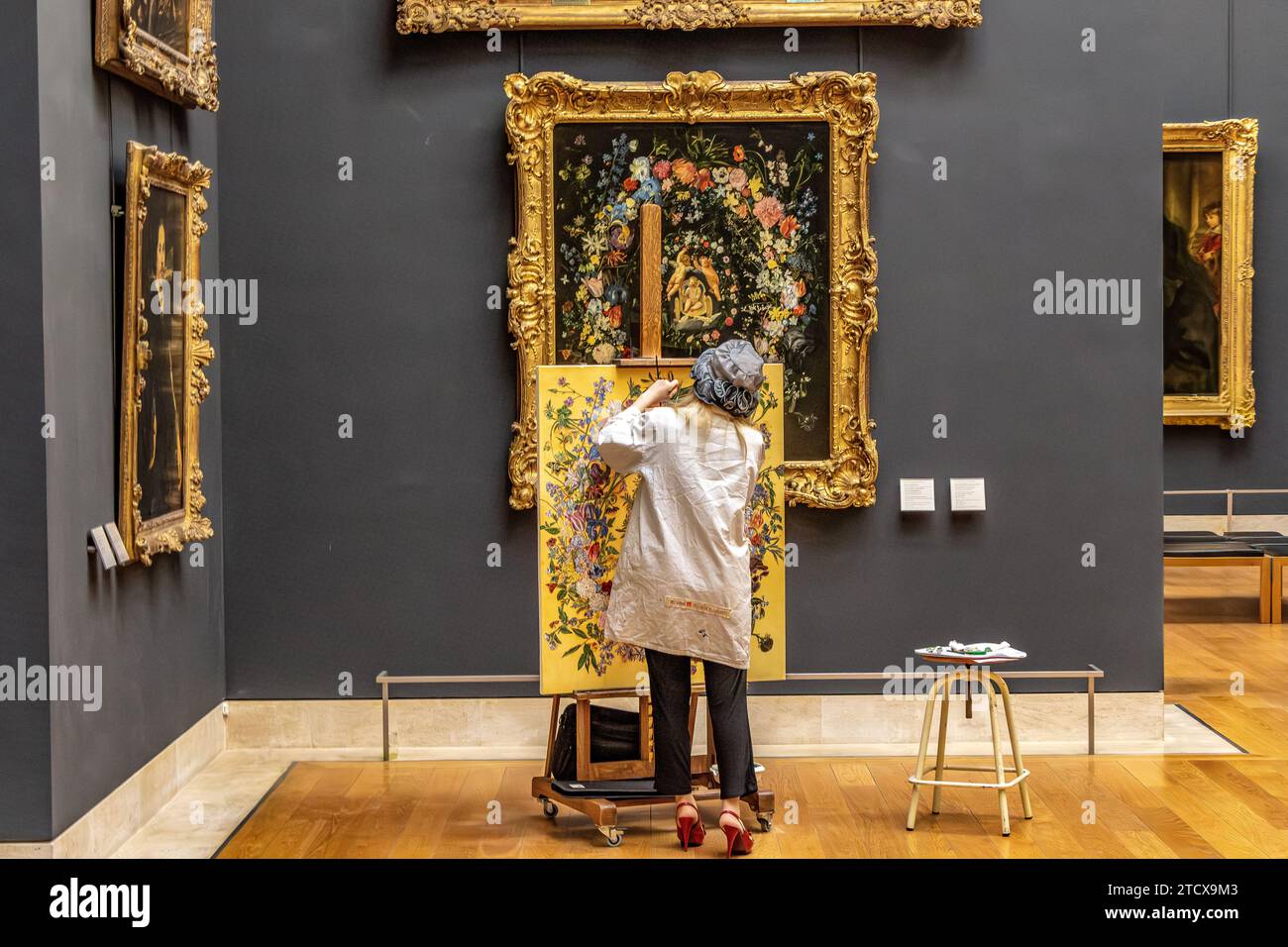 Une artiste femme copiant un tableau dans une galerie à l'intérieur du Musée du Louvre à Paris, France Banque D'Images