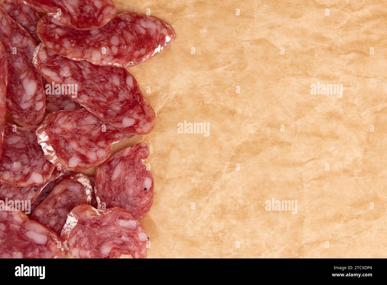 tranches de salami sur papier parchemin, concept de nourriture savoureuse avec saucisse de salami sur papier artisanal Banque D'Images