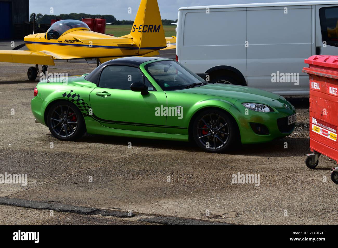 Vue latérale d'une Mazda Miata MX-5 vert clair avec toit convertible et autocollant de drapeau de course sur le côté, stationnée à White Waltham Airfield Banque D'Images