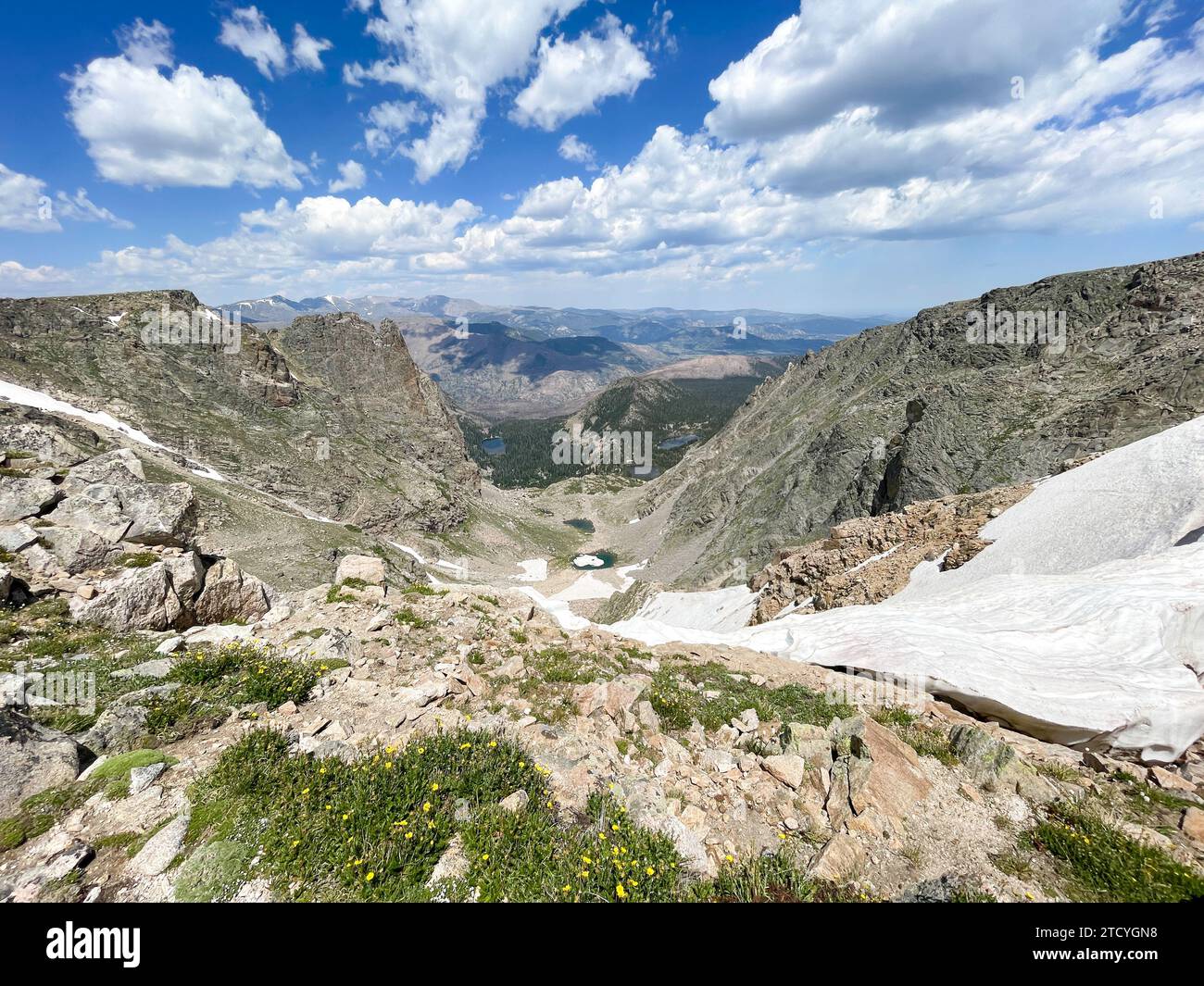 Surplombant une vallée verdoyante et des lacs alpins, cette vue depuis le parc national des montagnes Rocheuses capture l'essence de la nature sauvage de haute altitude. Banque D'Images