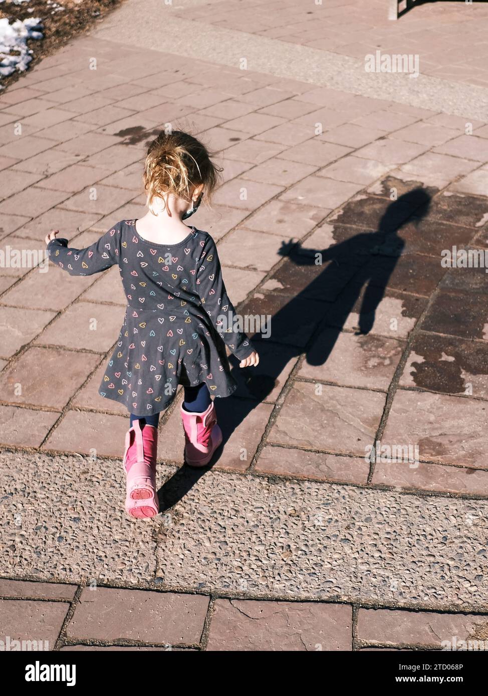 Enfant en vêtements décontractés marchant le long du sentier dans le soleil de printemps Banque D'Images