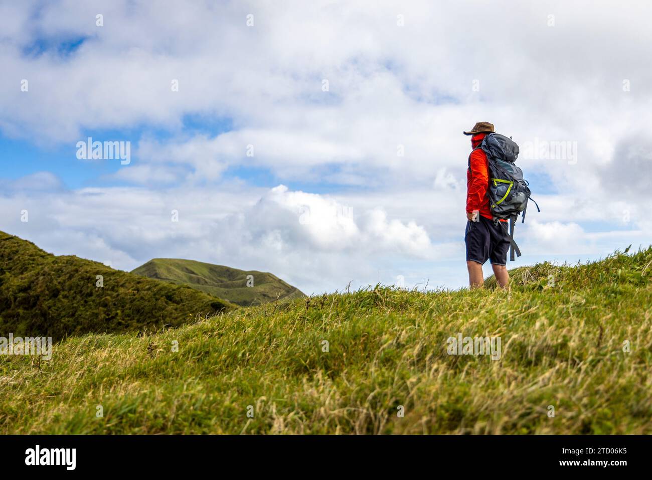 Randonneur avec un sac à dos debout sur une colline sur l'île de São Jorge aux Açores Banque D'Images