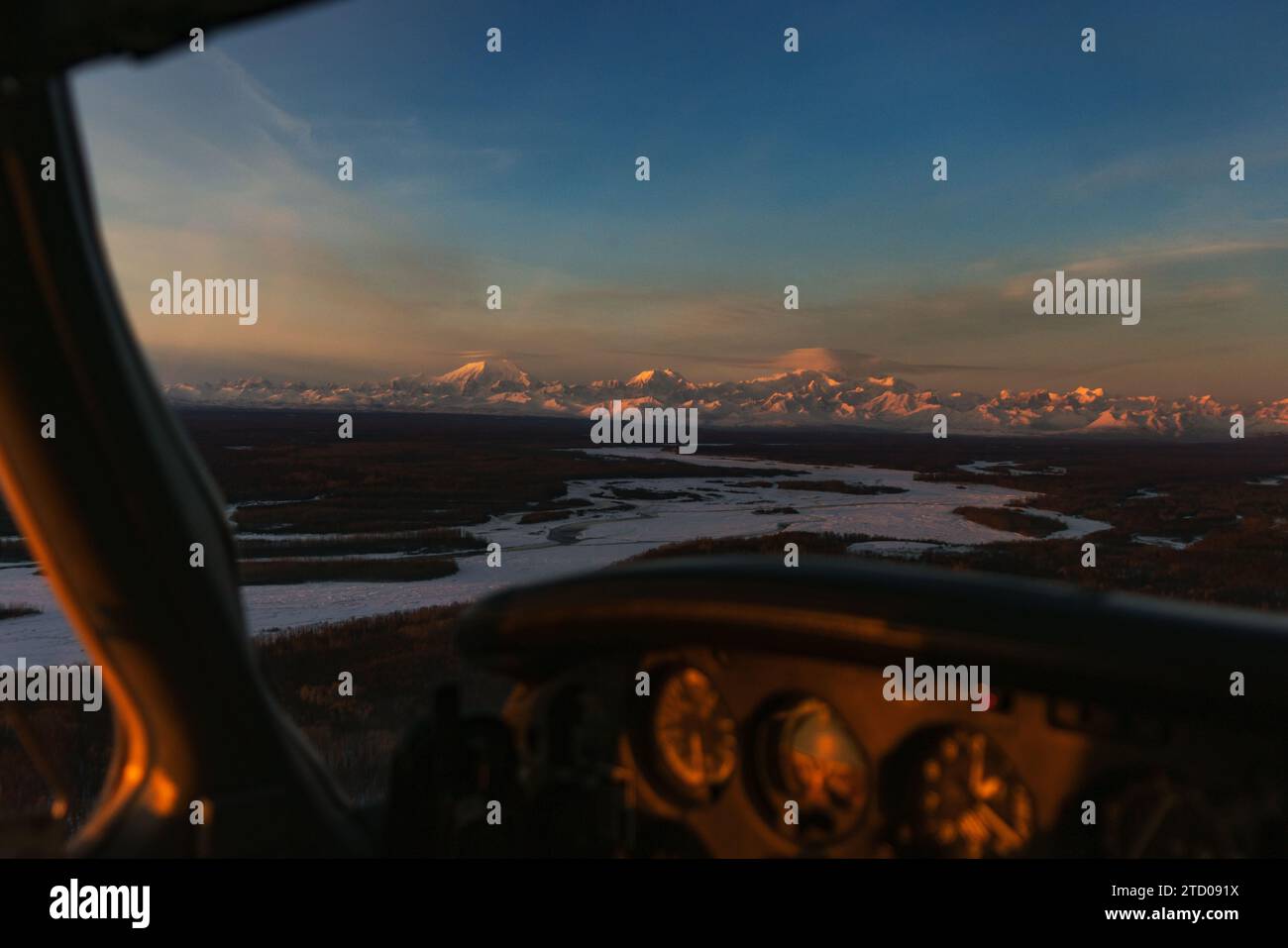 Le soleil se couche sur la chaîne de l'Alaska vu à travers une fenêtre d'avion Banque D'Images