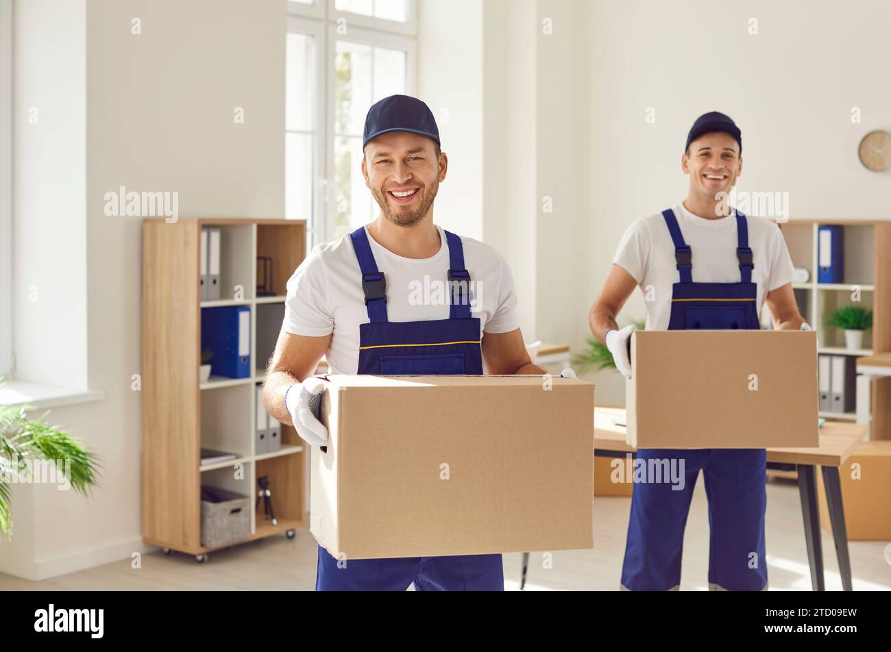 Travailleurs d'une entreprise de déménagement ou d'un service de livraison transportant des boîtes en carton ensemble Banque D'Images