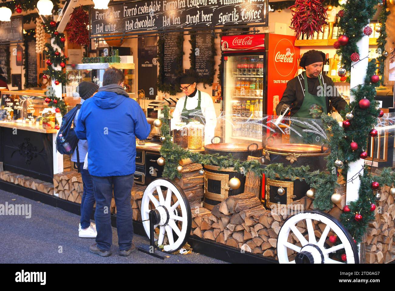 Clients achetant de la nourriture et des boissons à un stand, Foire de Noël 2023, Vorosmarty ter, Vorosmarty Square, Budapest, Hongrie Banque D'Images