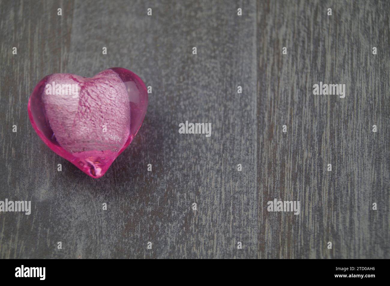 coeur en verre rose sur bois Banque D'Images