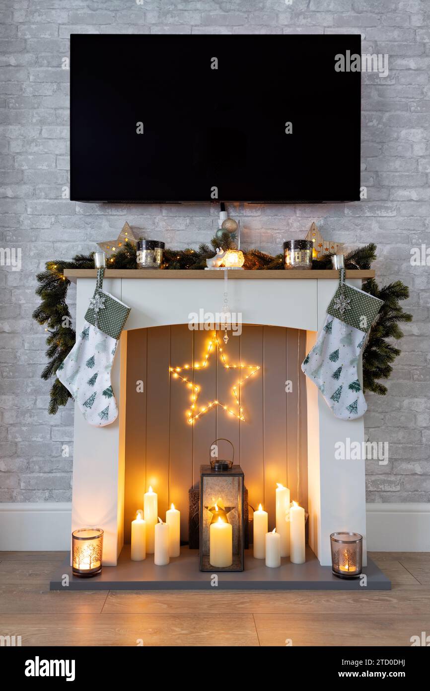 Autour de feu, habillé pour Noël avec guirlande, bas, étoile et bougies Banque D'Images