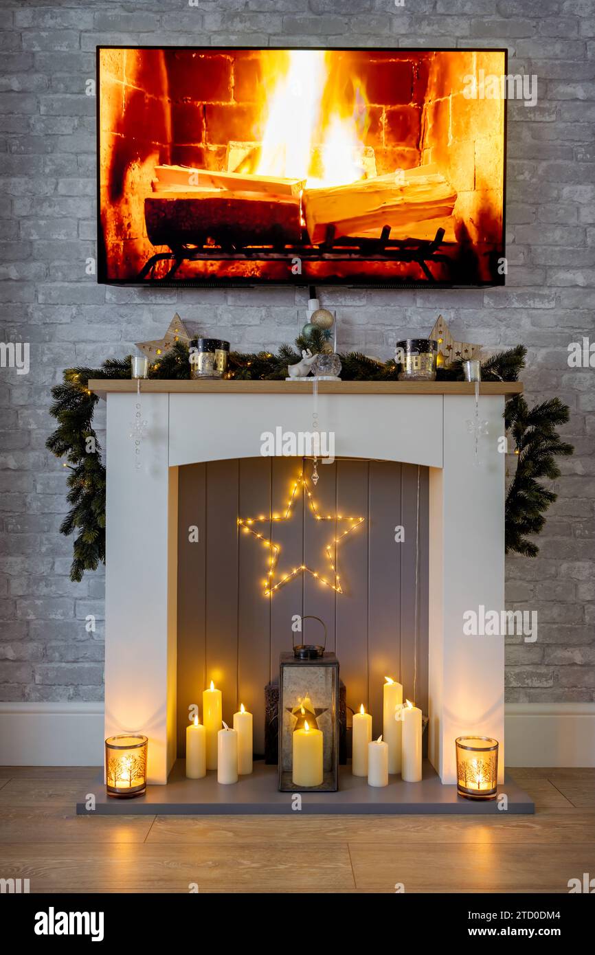 Autour de feu, habillé pour Noël avec guirlande, étoile et bougies et un feu sur la télévision Banque D'Images