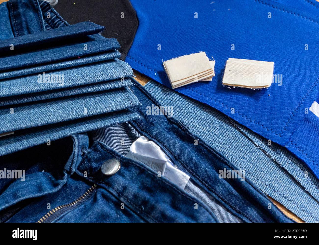 Une vue rapprochée de divers textiles denim et patchs de tissu disposés pour la réparation de vêtements ou les efforts de couture créative. Banque D'Images