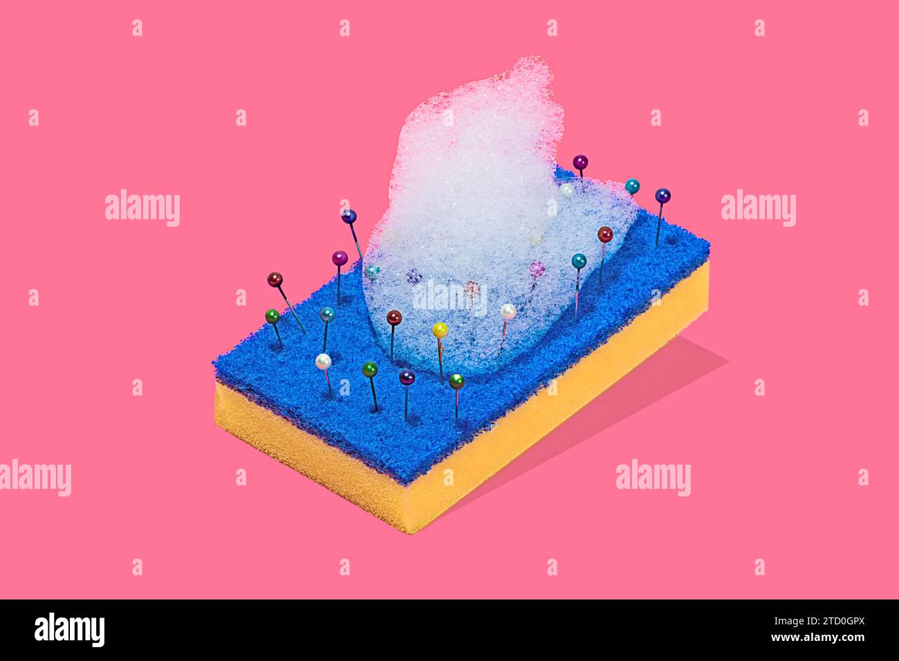 Une représentation créative d'un tampon à récurer bleu et jaune avec des épingles colorées et des bulles de mousse sur un fond rose Banque D'Images