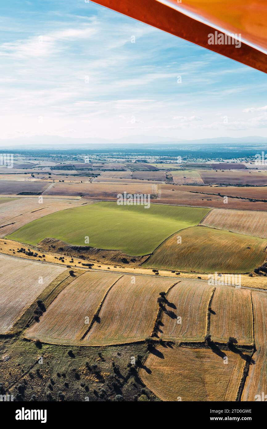 Le patchwork vibrant de champs agricoles se déploie en dessous d'une perspective aérienne, vu du point de vue de l'aile d'un petit avion Banque D'Images