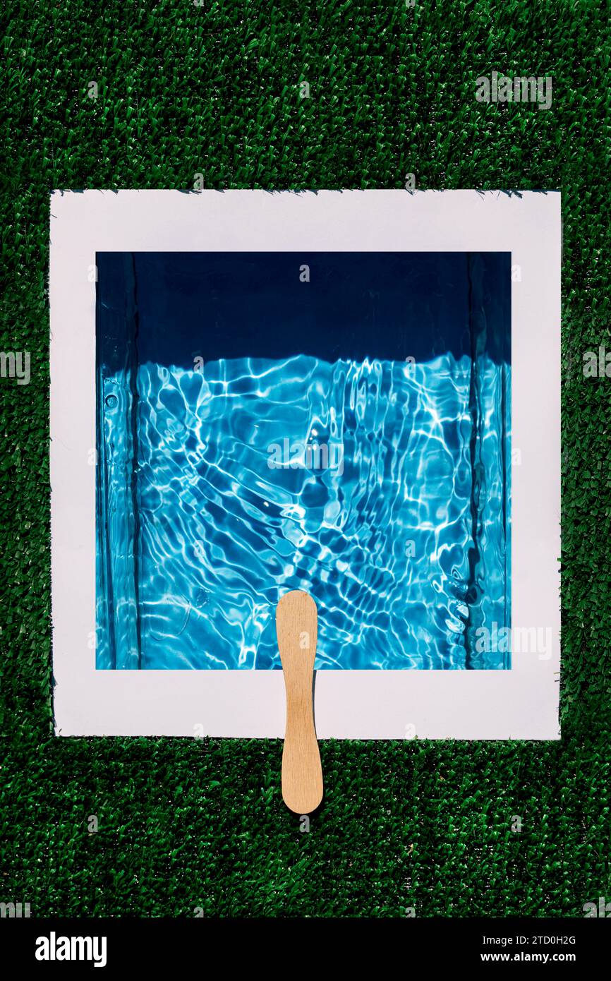 Vue aérienne de dessus de la plate-forme de plongée faite avec bâton en bois sur l'eau ondulée dans la piscine isolée sur fond artificiel vert Banque D'Images
