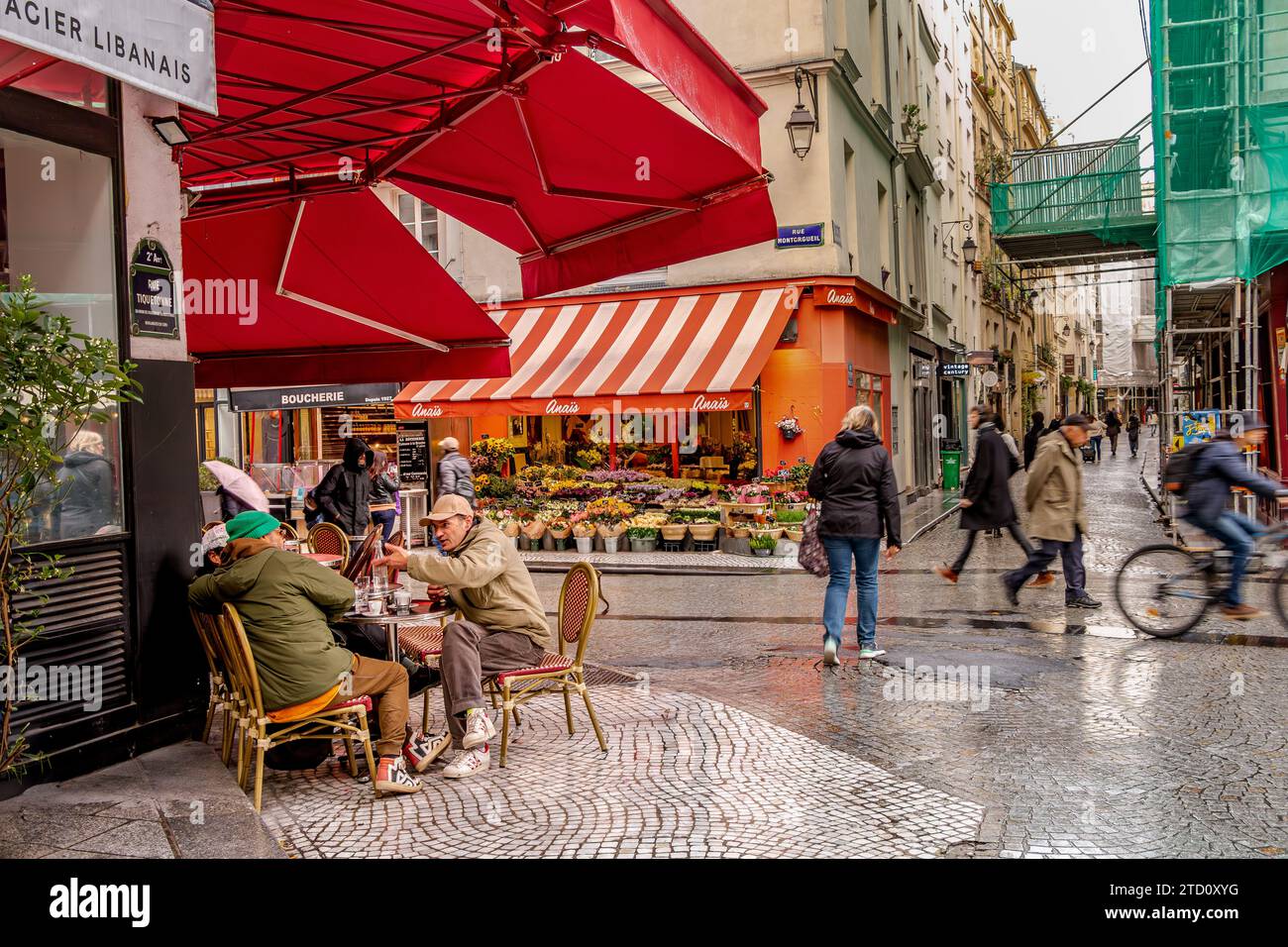 Personnes ayant une discussion à une table devant un café de la rue Montorgueil dans le 2e arrondissement de Paris, France Banque D'Images