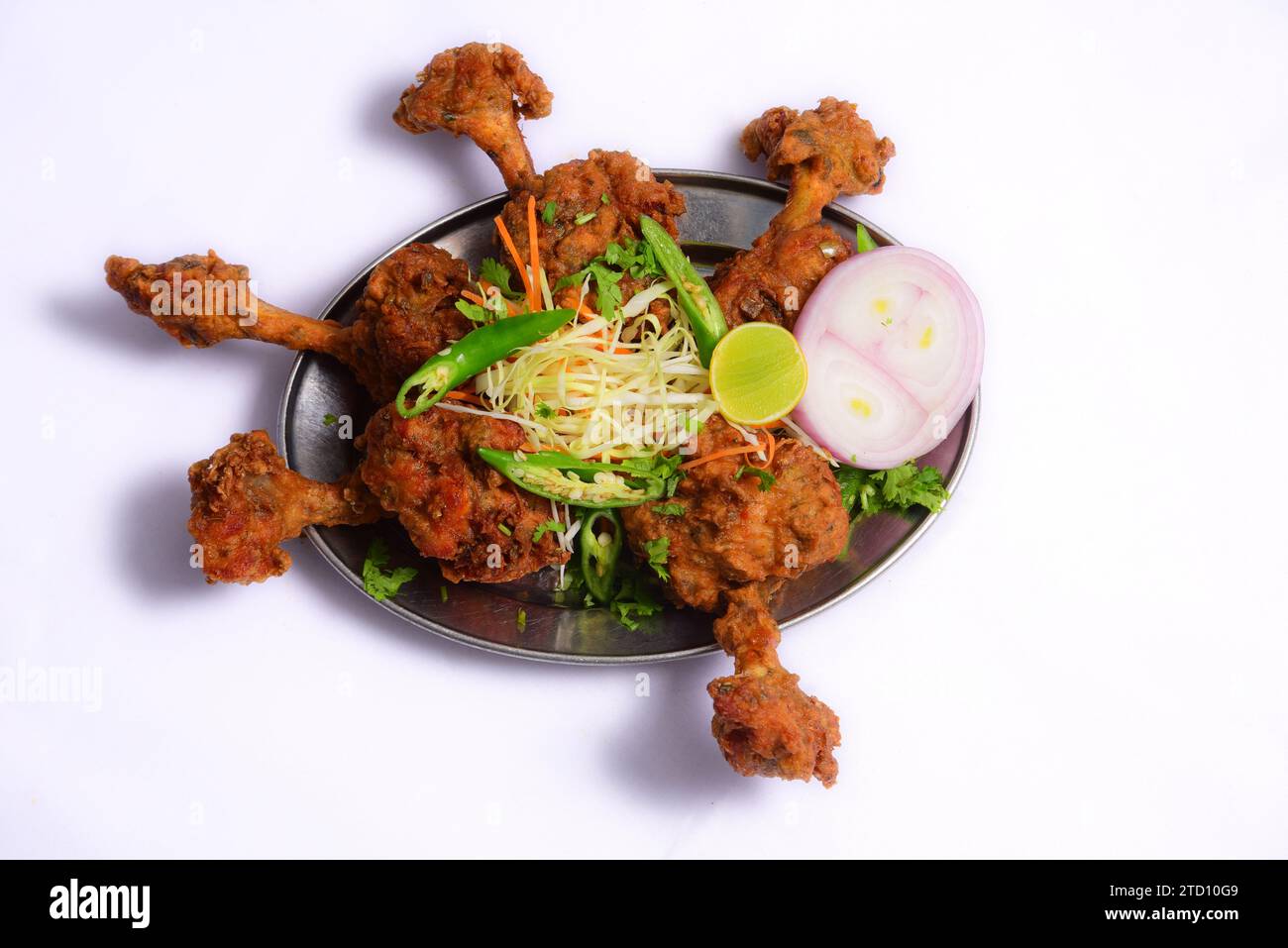 Le pilon de poulet Lollipop est mariné puis frit ou cuit au four jusqu'à ce qu'il soit croustillant servi avec de la salade dans une assiette Banque D'Images