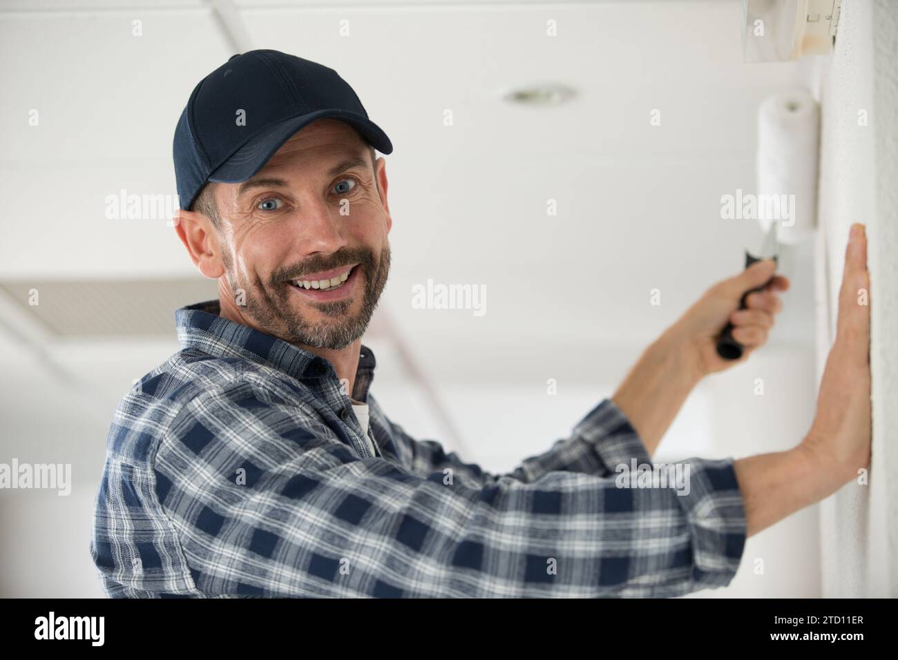 portrait d'un homme utilisant un rouleau à peinture Banque D'Images