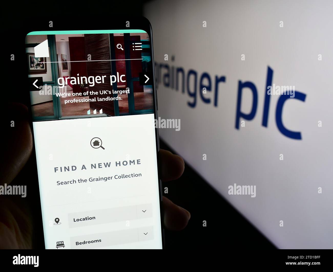Personne détenant le smartphone avec la page Web de la société immobilière résidentielle britannique Grainger plc avec logo. Concentrez-vous sur le centre de l'écran du téléphone. Banque D'Images