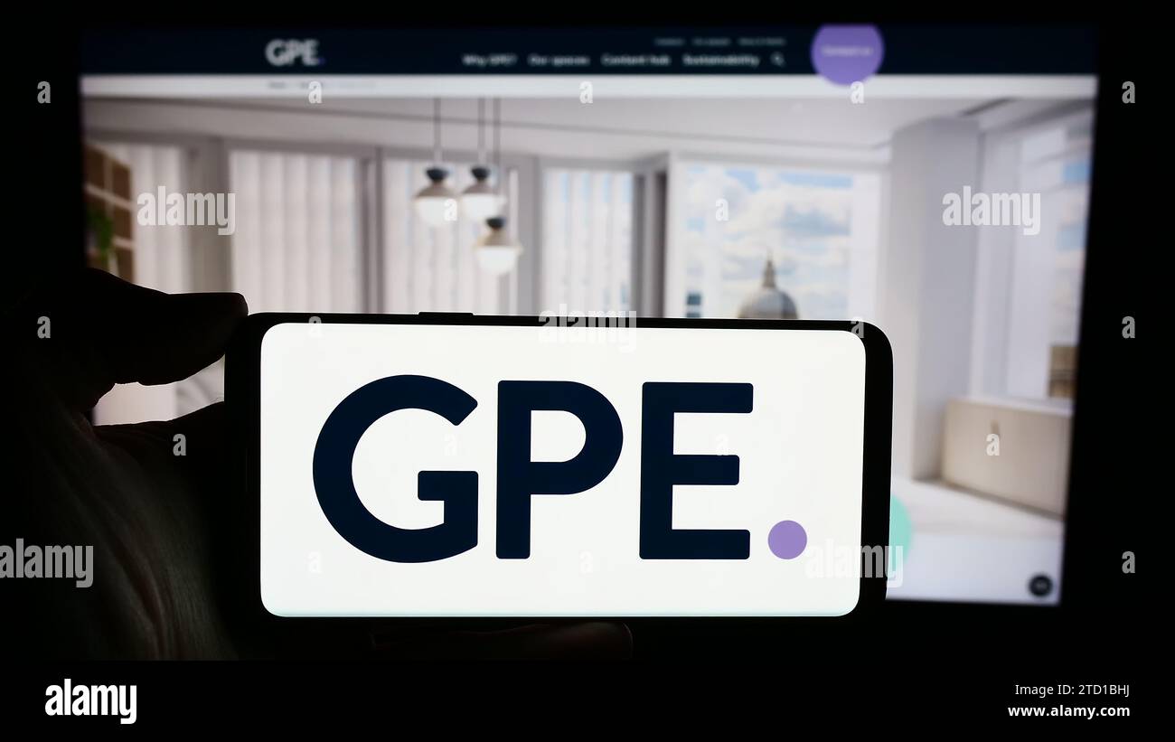 Personne tenant un téléphone portable avec le logo de la société immobilière britannique Great Portland Estates plc (GPE) devant la page Web. Concentrez-vous sur l'affichage du téléphone. Banque D'Images
