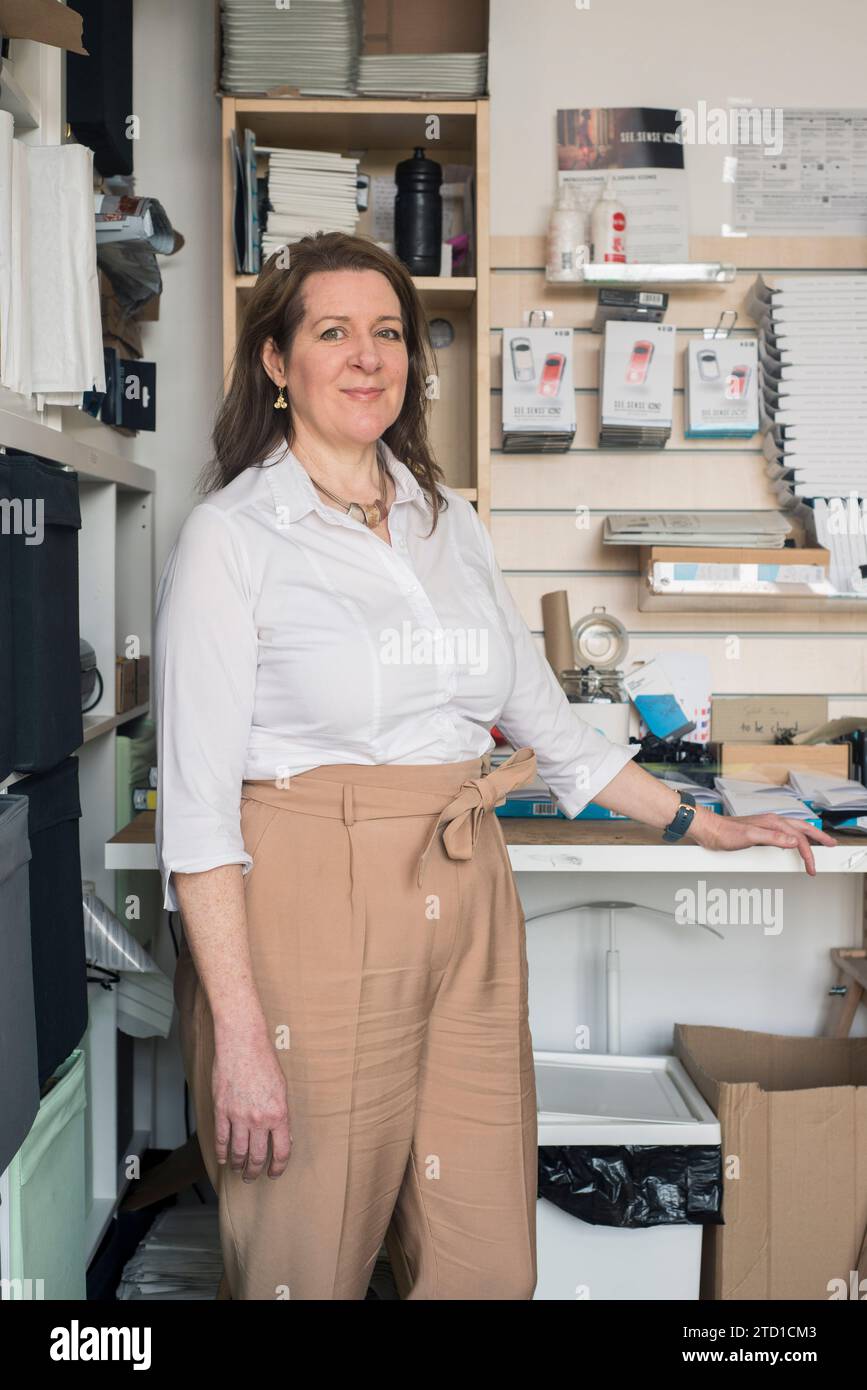 Un propriétaire de petite entreprise et fabricant de technologie pose pour un portrait à leur poste de travail dans leur unité industrielle. Banque D'Images