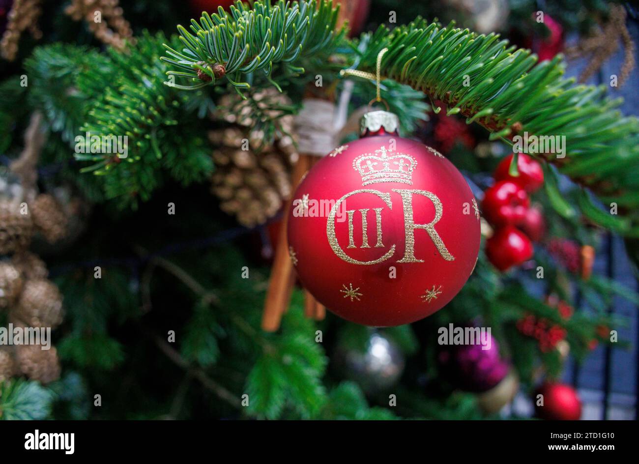 Londres, Royaume-Uni 15 déc. 2023 Un baubel avec un signe du roi Charles le troisième, hommage au nouveau roi. Le sapin de Noël Downing Street devant la porte du numéro 10, la maison du Premier ministre britannique. Banque D'Images