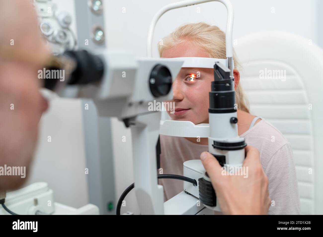 Gros plan d'une fille vérifiant la vision avec un tonomètre à la clinique oculaire Banque D'Images